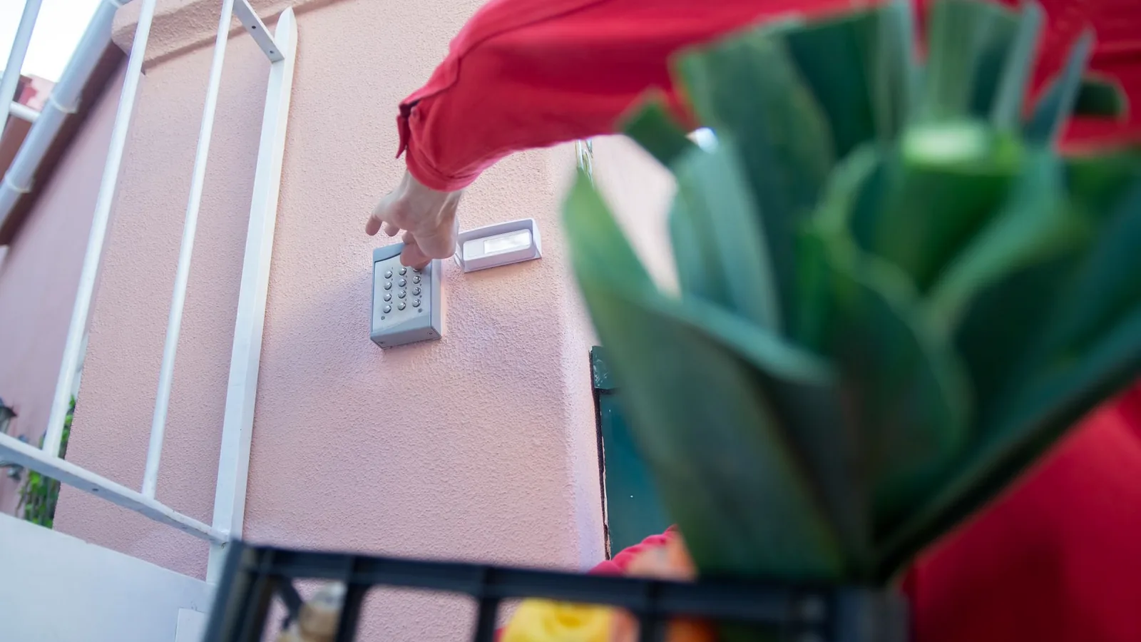 Person using an outdoor gate access keypad